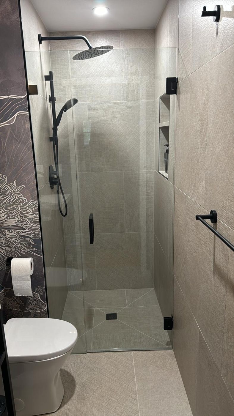 Walk-in frameless shower with matte black hardware